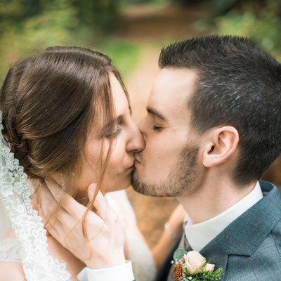 Yvonne und Marcel küssen sich bei ihrer Herbsthochzeit im Wald in der Eifel